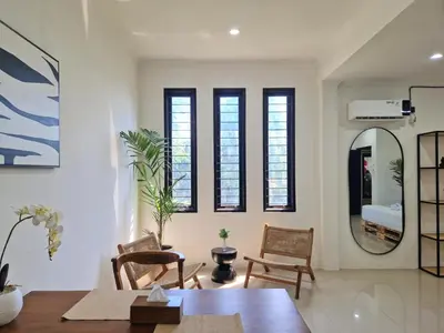 a living room with a table and chairs and a mirror at Nice Place To Stay - Cozy Living in Seminyak