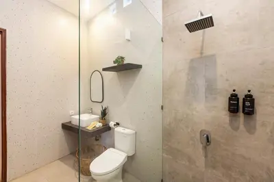 a bathroom with a toilet and a glass shower at Villa Lavinia - Private Pool Villa - Seminyak Kuta - Double Six Beach in Seminyak