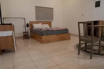 a bedroom with a bed and a chair in a room at Mirri House Kerobokan in Seminyak