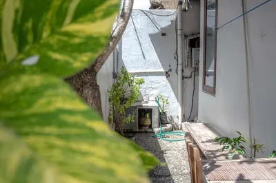 an alley with benches and plants on the side of a building at Mirri House Kerobokan in Seminyak