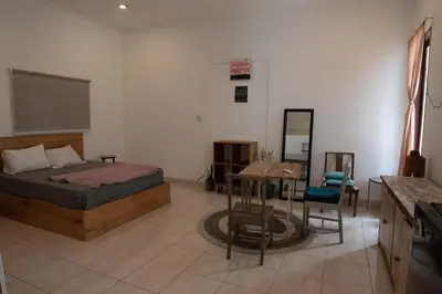 a bedroom with a bed and a table and a desk at Mirri House Kerobokan in Seminyak