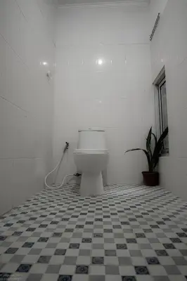 a bathroom with a toilet and a tile floor at Mirri House Kerobokan in Seminyak
