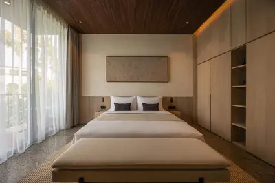 a bedroom with two beds and a large window at Marvee Suites Bali in Canggu
