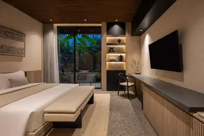 a bedroom with a large bed and a television at Marvee Suites Bali in Canggu