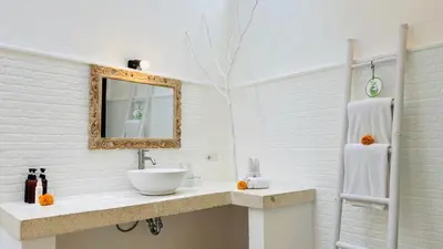 a white bathroom with a sink and a mirror at Villa Mandari in Seminyak