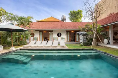 a swimming pool in front of a house at Villa Bali Manis by The Bali Agent - Central Seminyak 4BR Villa with Private Pool, Perfect for Families & Groups in Seminyak