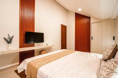 a bedroom with a bed and a flat screen tv at Renjana Villa-2BR Modern Tropical Villa in Seminyak with Private Pool & Rice Field View in Seminyak