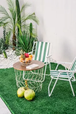 a table and chairs on a green rug with a bowl of fruit at Renjana Villa-2BR Modern Tropical Villa in Seminyak with Private Pool & Rice Field View in Seminyak