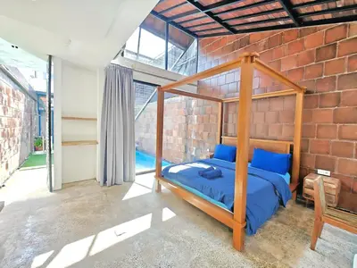 a bedroom with a bed and a brick wall at Large Villa Jimbaran With Pool & WiFi by 2ndHome in Jimbaran