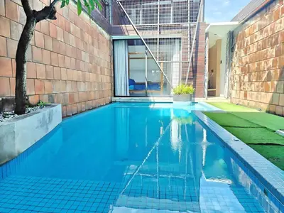 a swimming pool in a house with blue water at Large Villa Jimbaran With Pool & WiFi by 2ndHome in Jimbaran