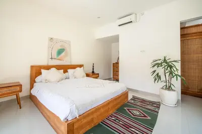 a bedroom with a bed and a potted plant at 3BR Green Oasis downtown Berawa Canggu in Canggu