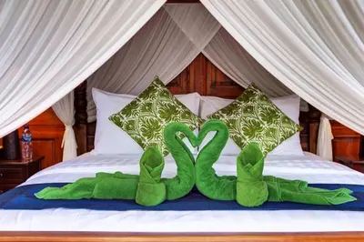a couple of green snakes sitting on a bed at The Cottage By Selasih in Seminyak