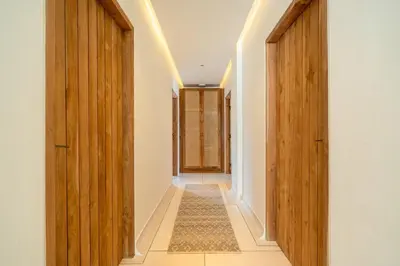 an empty hallway with wooden doors and a rug at Elegant 4BR Villa downtown Berawa Canggu in Canggu