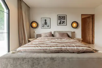 a bedroom with a large bed with two mirrors on the wall at Elegant 4BR Villa downtown Berawa Canggu in Canggu