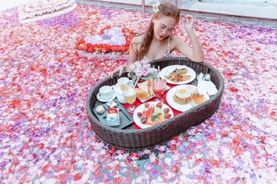 a woman sitting on a floor with a table of food at Private Pool Villas Kuta Bali in Badung