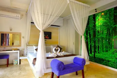 a bedroom with a canopy bed with a large window at Private Pool Villas Kuta Bali in Badung