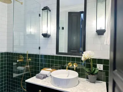 a bathroom with a sink and a green tiled wall at Martini Beachside Villa 5 in Canggu