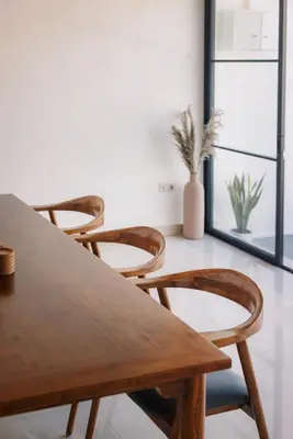 a wooden table and chairs in a room with a window at Villa Batu Putih 3 Seminyak in Seminyak