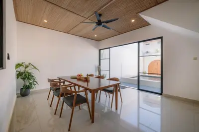 a dining room with a table and chairs and a ceiling fan at Villa Batu Putih 3 Seminyak in Seminyak