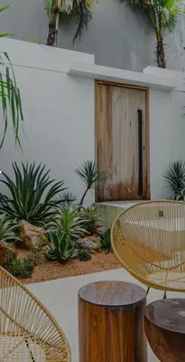 a patio with a table and chairs and plants at Cocon Maison Timal in Kerobokan