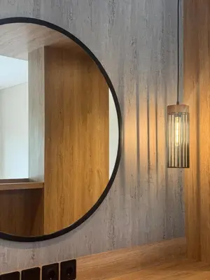 a circular mirror on a wall with a light at Family Haven 6BR Luxe Villa in Berawa, Canggu in Canggu
