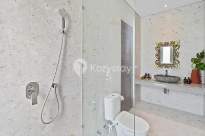 a bathroom with a shower and a toilet and a sink at Andrew Villa by Kozystay - Umalas in Canggu