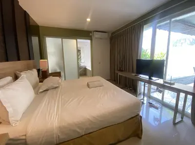 a bedroom with a large bed and a television at 2 bedroom with pool tropical in Nusa Dua