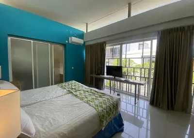 a bedroom with a bed and a desk and a window at 2 bedroom with pool tropical in Nusa Dua