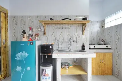 a small kitchen with a refrigerator and a sink at Kamar Kodel2 Apt in Seminyak