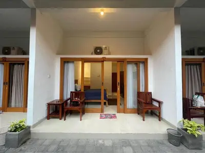 a room with a table and chairs and a bedroom at Kamar Kodel1 in Seminyak