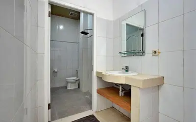 a bathroom with a sink and a toilet and a mirror at Kamar Kodel1 in Seminyak