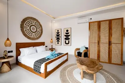 a bedroom with a bed and a chair at Brand new - spacious complex Villas Virland - center Seminyak in Seminyak