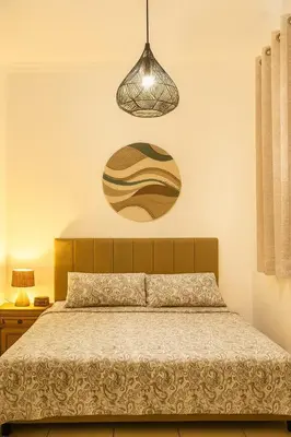 a bedroom with a bed and a hanging light at Villa Cempaka - Pemogan in Denpasar