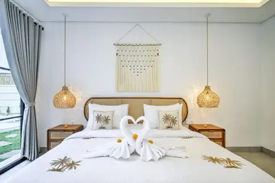 a bedroom with a bed with a flower on it at Villa Esha I in Seminyak