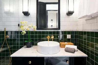 a bathroom with a white sink and green tiles at Martini Beachside Villa 6 in Canggu