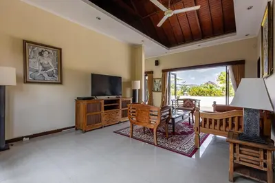 a living room with a television and a table and chairs at 5 Bedroom Luxury Villa With Huge Garden & Pool 150-Metres To Seminyak Beach in Seminyak