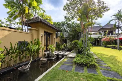 a garden in front of a house with a pond at 5 Bedroom Luxury Villa With Huge Garden & Pool 150-Metres To Seminyak Beach in Seminyak