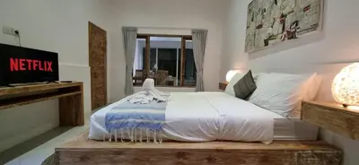 a bedroom with a bed with white sheets and a window at Tropical 2br private pool Villa in central Seminyak in Seminyak