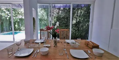 a table with plates and glasses and a vase of flowers at Tropical 2br private pool Villa in central Seminyak in Seminyak