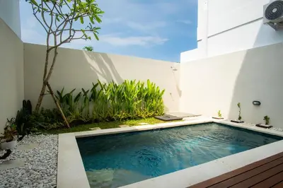 a swimming pool in the side of a building at Modern tropical House Villa in Seminyak