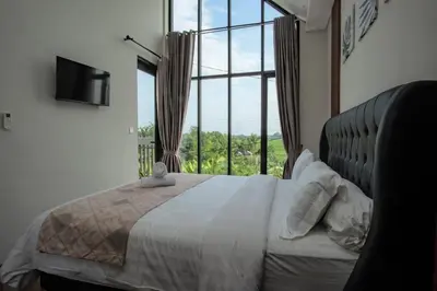 a bedroom with a large bed with a large window at Modern tropical House Villa in Seminyak