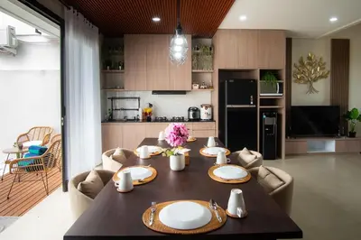 a dining room table with plates on it in a kitchen at Modern tropical House Villa in Seminyak