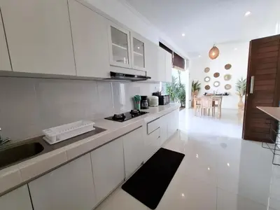 a white kitchen with a sink and a counter at Villa A La Cool Seminyak in Seminyak