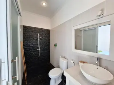 a bathroom with a sink and a toilet and a mirror at Villa A La Cool Seminyak in Seminyak