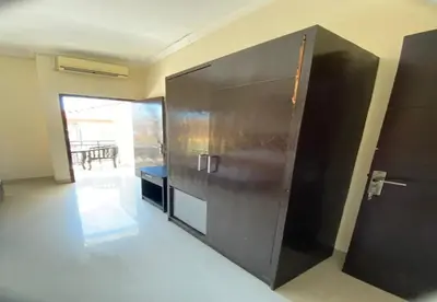 a large black refrigerator in a room with a table at Hotel Near Beach Ayu inn Kuta in Kuta