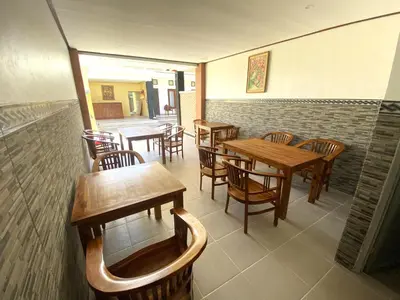 a dining room with wooden tables and chairs at Bidadari Homestay Nusa Dua in Nusa Dua