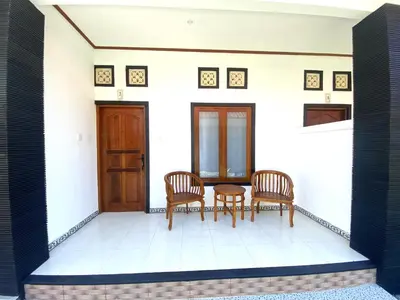 two chairs and a table in a room at Bidadari Homestay Nusa Dua in Nusa Dua