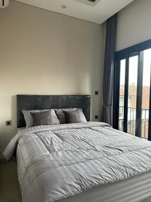 a bedroom with a large bed and a window at Kubu Gandi Homestay in Denpasar
