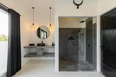 a bathroom with a shower and a mirror at Aaryan Villa 1 in Seminyak