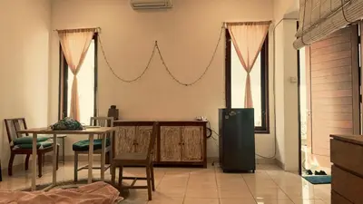 a living room with a table and a refrigerator at kerobokan cozy house by kenta in Seminyak
